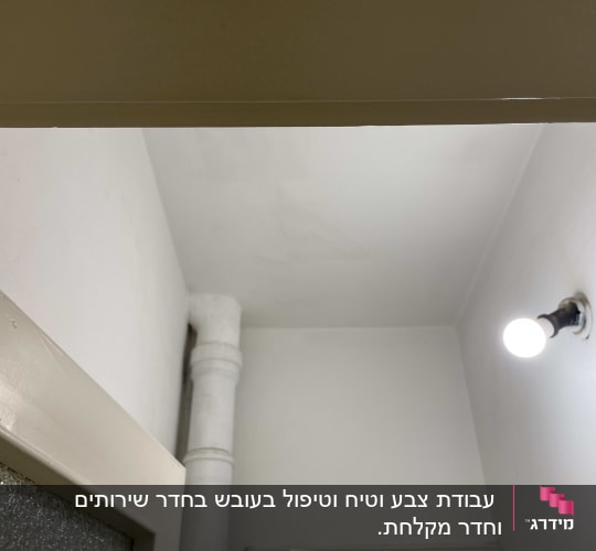 קיר צבוע בלבן עם צינור ותאורה